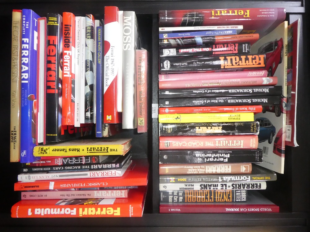 2 Shelves of Ferrari hardback books and a Stirling Moss biography