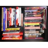 2 Shelves of Ferrari hardback books and a Stirling Moss biography