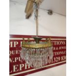 An old three tier ceiling light with pendant drops