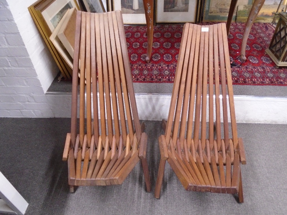 A pair of teak folding garden chairs