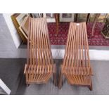 A pair of teak folding garden chairs