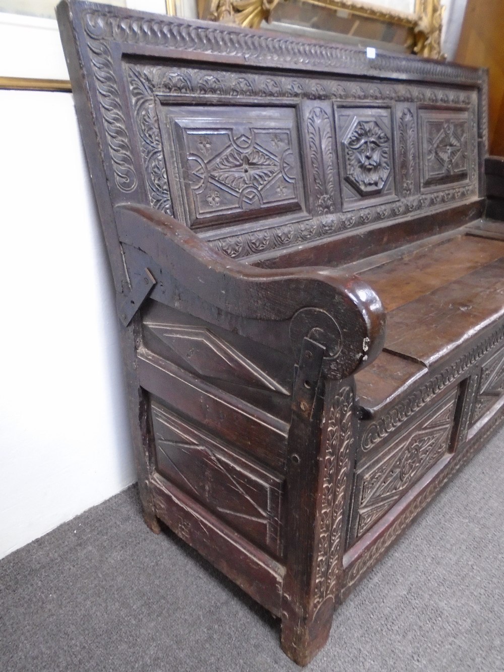 An 18th century and later carved oak monksbench with box seat and scroll arms, probably continental, - Image 2 of 3