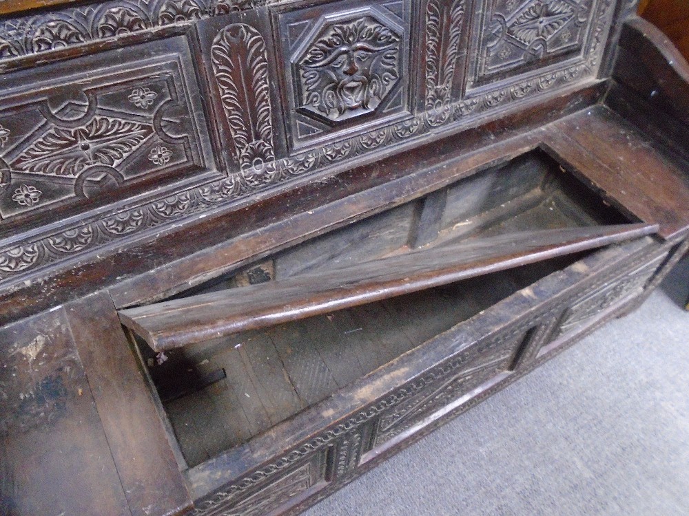 An 18th century and later carved oak monksbench with box seat and scroll arms, probably continental, - Image 3 of 3