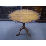 A Georgian style mahogany tripod table having shaped border with carved scallops 76cms