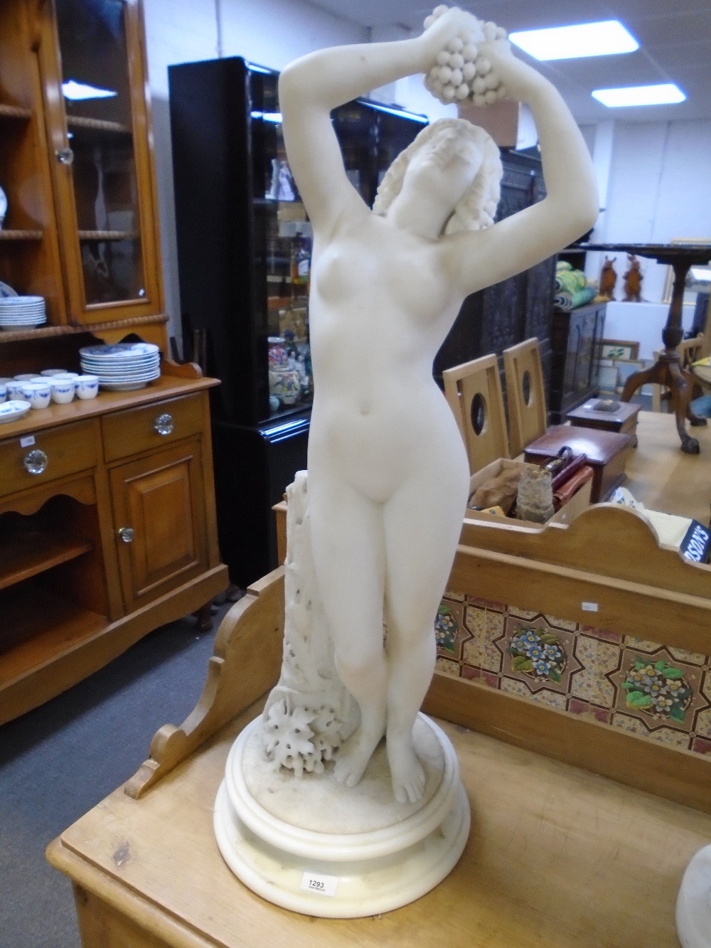 19th Century white marble figure of a female nude holding grapes beside a tree stump, 90cm
