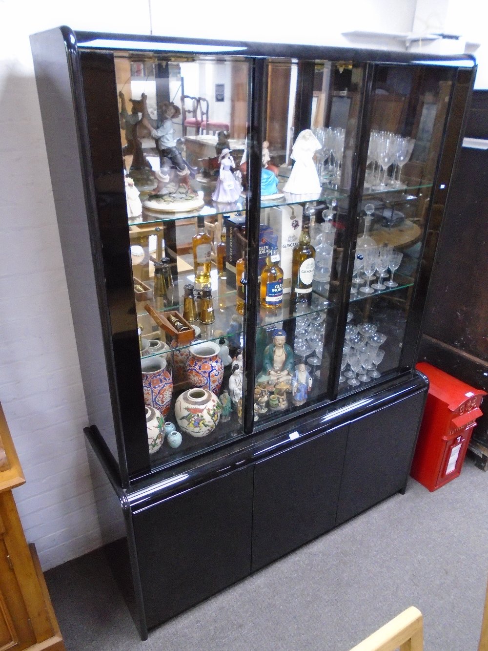 A modern Italian black glass display cabinet with cupboards below, 147.5cms