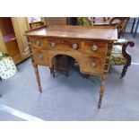 An antique mahogany writing table with five drawers with rosewood inlaid panels on turned legs,