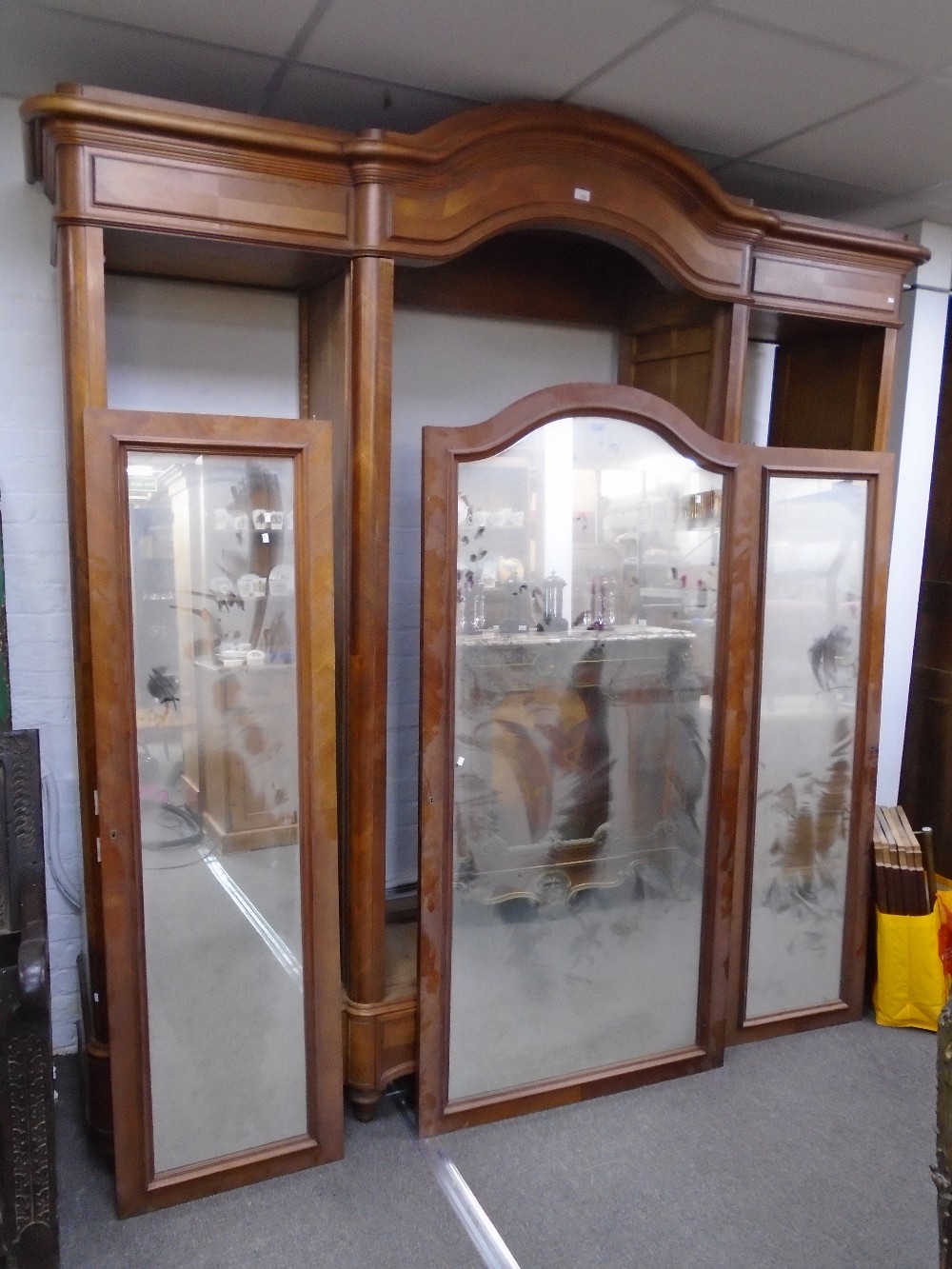 An antique French three section wardrobe having mirrored doors on turned feet