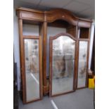 An antique French three section wardrobe having mirrored doors on turned feet