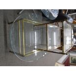 An oval glass top coffee table with a brass effect base to include a similar two tier table