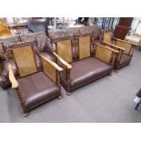 A pair of 1930's oak bergere armchairs and matching two seat settee with barley twist supports and