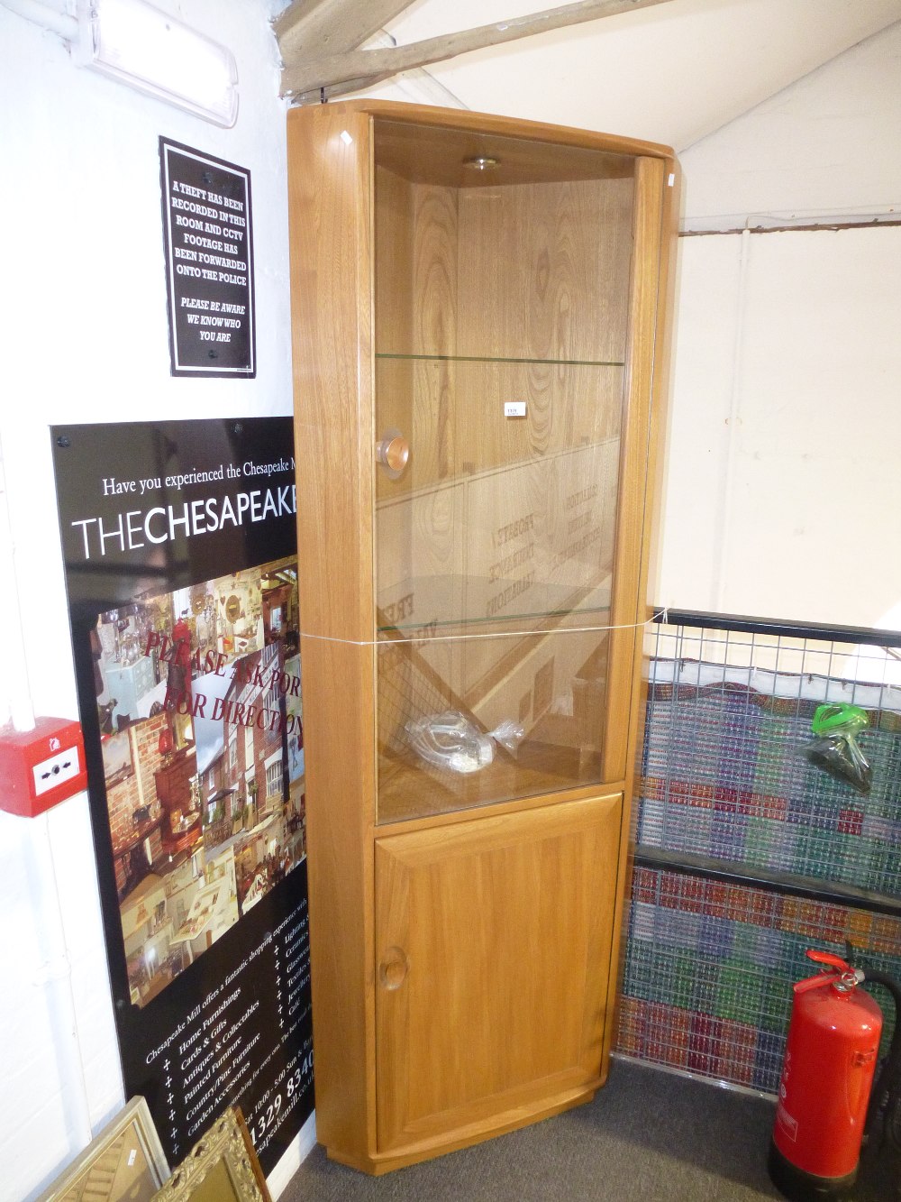 An ercol light elm and beech corner cabinet & cupboard; glazed top hal with 2 glass shelves and