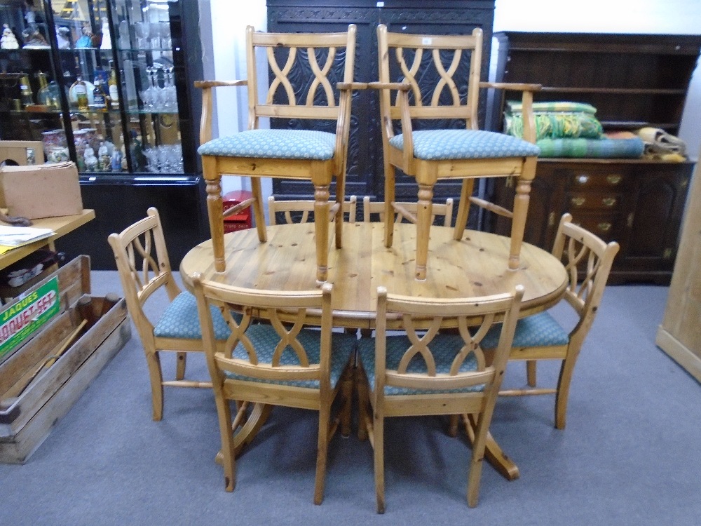 A Ducal pine oval dining table with concelled leaf and a set of eight Ducal dining chairs to include