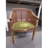 A French carved beech tub chair with cane seat and back