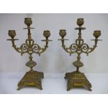 A pair of old brass candelabras on square base