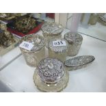 Collection of various Edwardian cut glass toilet jars, all with embossed silver lids, hallmarked for