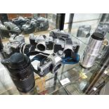 A shelf of vintage camera and lenses