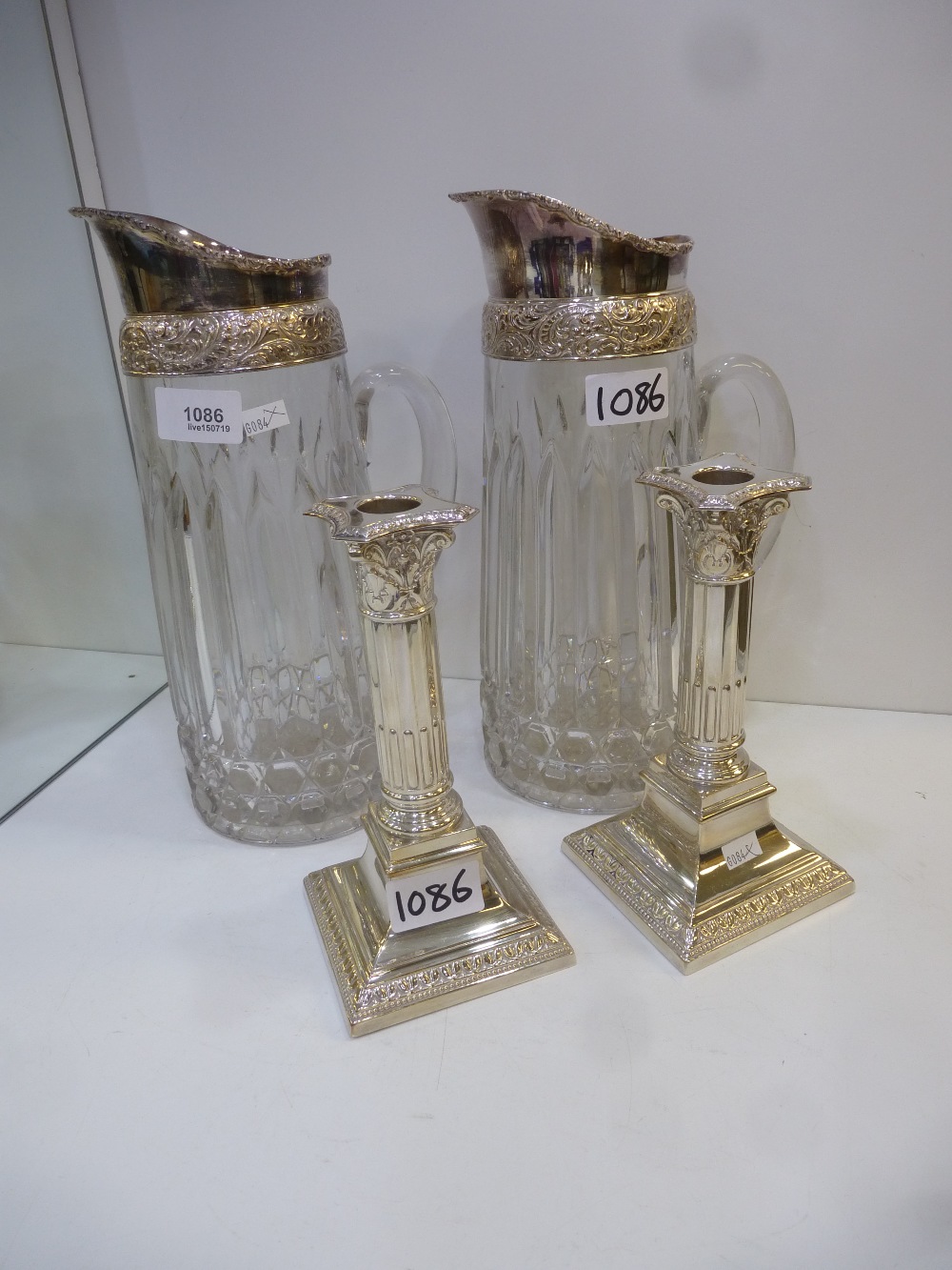 Pair of moulded clear glass jugs with silver plated mounts, 29cm high, together with a pair of