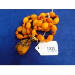 Baltic amber 3 strand bead bracelet with pendant drop and yellow coloured metal toggle clasp, approx