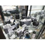 A shelf of vintage cameras and lenses