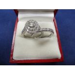 Contemporary platinum and diamond ring of oval stepped design, central diamond 0.5ct, flanked to