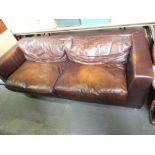 Three seater modern leather sofa with loose cushions and nice patina