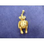 9ct yellow gold pendant modelled as a bear with articulated joints, sapphire set eyes, ruby bow,