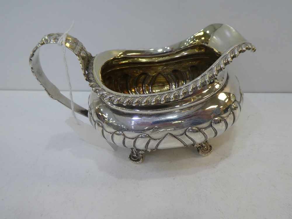 George III silver milk jug, half gadroon decoration, leaf pattern handle on 4 leaf and shell pattern