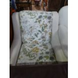 Cream upholstered arm chair with floral covered seat and back