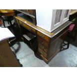 Mahogany kneehole desk with green tooled leather above 9 drawers