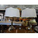 Pair of twin branch brass table lamps with cream shades