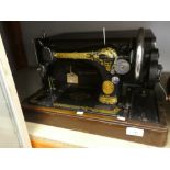 A hand cranked Singer sewing machine, with case