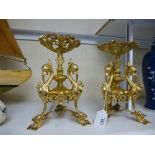 A pair of gilt metal stands decorated with birds on tripod supports