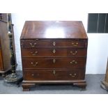 An antique oak bureau with four long graduated drawers on ogee bracket feet, 96 cms