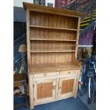 An antique stripped pine dresser with rackback, 121cms