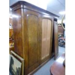 A Victorian triple wardrobe having central mirror door on plinth base.