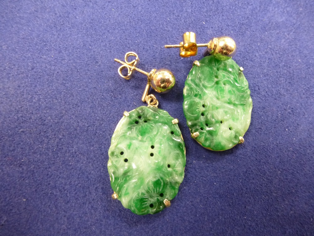 Pair of Oriental yellow coloured metal & carved oval jade earrings, approx. 3.5cm long X 2cm wide,