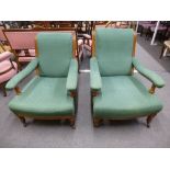 A pair of Victorian oak open armchairs on turned front legs in the style of Howard