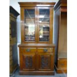 A late Victorian walnut bookcase with cupboard base with carved doors, 104 cms