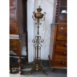 An early 20th century brass and copper plated standard lamp adjustable oil lamps, converted to