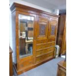 A Maple and compactum wardrobe with a pair of carved cupboards doors, six drawers and single robe,