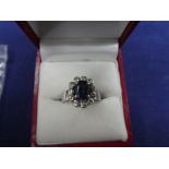 18K white gold dress ring set with central Sapphire surrounded by 11 diamonds, shank stamped 18K,