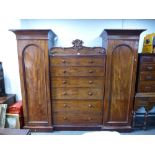 A Victorian mahogany wardrobe having six central graduated drawers, 247cms.
