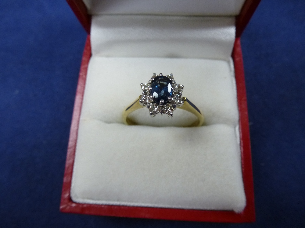 9ct yellow and white gold ring set with central blue coloured stone surrounded by 8 diamonds.