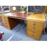 A 1950's twin pedestal desk with partially leathered top with six drawers, stamped United Kingdom