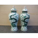 A pair of Chinese baluster vases and covers decorated dragons, 38.5 cms