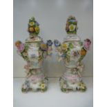 A pair of Sitzendorf style floral encrusted pot pourri urns, decorated cherubs, 1 lid A/F, some