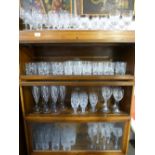 A shelf of glass tumblers, a set of eight Hock glasses and sundry glassware