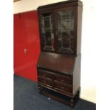 An oak bureau bookcase, the top with caddy moulded cornice above leaded glass doors enclosing