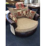 A circular love seat, the tub chair with loose cushions having studded upholstery and padded